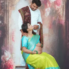 An intimate moment between expecting parents during their traditional maternity photoshoot. The husband's loving gaze and the traditional attire create a heartwarming and culturally rich portrait.