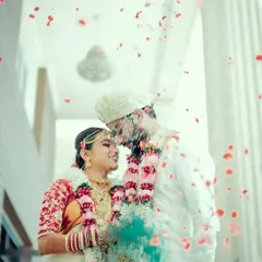 A dreamy and romantic portrait of a couple during their wedding ceremony, with flower petals showering down around them.