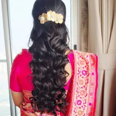 The back view of a half-up style with long, flowing curls. I used a beautiful gold floral clip to secure the hair, adding a touch of elegance to this classic look.