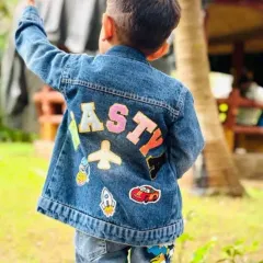 This personalized denim jacket for a little boy features his name and cool patches like a rocket, airplane, and race car.