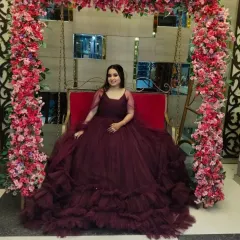 Another view of the popular wine-colored ruffled gown, showing its full volume and dramatic flair, pictured here in a beautiful event setting.