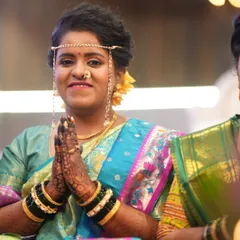 That special mehendi glow. This happy bride is all smiles during her wedding ceremony, with her beautifully stained hands in a traditional namaste pose.