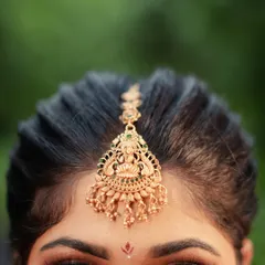 A detailed shot focusing on the exquisite temple jewelry maang tikka. I love capturing these small details that are so significant to the overall bridal look.