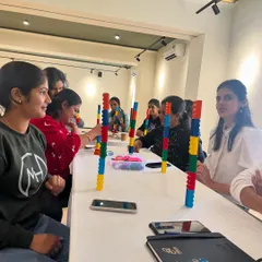 A group of teachers fully engaged in a building challenge during the Six Bricks workshop. This hands-on practice is crucial for understanding how to guide similar activities in their own classrooms.