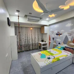 An adventure-themed kids' room with a playful hot-air balloon and mountain wallpaper. The space includes a custom bed with storage, a study desk, and fun elements like a rope ladder.