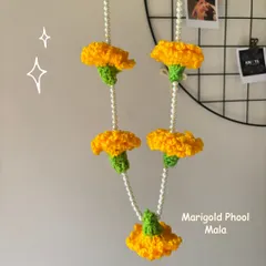 A handmade crochet Marigold Phool Mala (genda phool) hanging on a wall grid, perfect for adding a festive touch to your home.