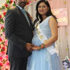 Celebrating a baby shower in style. This mom-to-be looks radiant in a light blue gown with delicate white lace details, perfect for her special day.