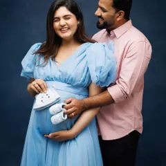 A joyful and candid moment with the parents-to-be. Using tiny baby shoes as a prop adds a sweet and playful touch to this happy couple's portrait.