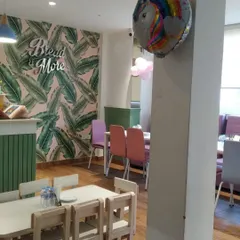 The stylish interior of our 'Bread & More' cafe corner, featuring modern wallpaper and dedicated seating for kids and adults.