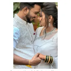 An intimate close-up in a lush, green setting. The soft natural light filtering through the leaves creates a beautiful, gentle atmosphere for this romantic couple portrait.