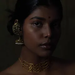 I love playing with shadows and low-key lighting to create something truly artistic. This portrait uses a painterly approach to light, sculpting the model's features and highlighting the warm tones of the gold jewelry against her skin. It shows my ability to create deep, moody, and soulful beauty images.