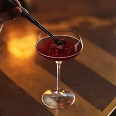 The final touch. A star anise is carefully placed on our Pickled Pom Whiskey, adding an aromatic finish to this bold and tangy cocktail.