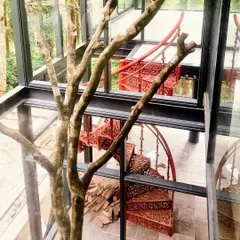 A staircase can be a work of art. For our Yercaud villa project, we installed this ornate, red cast-iron spiral staircase, creating a stunning focal point that contrasts beautifully with the modern glass and steel structure. It's a detail that adds unique character and showcases our love for distinctive architectural elements.