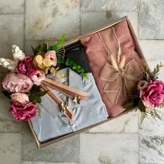 Engagement trousseau packaging for a client. This tray features elegantly packed outfits for the groom, adorned with a stunning arrangement of pink and burgundy flowers.