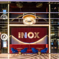 The entrance to an auditorium at INOX, Rajouri Garden, is designed to be a grand statement. The combination of the bold, backlit INOX branding, plush red velvet, and checkered flooring creates a sense of occasion and excitement before the film even begins.