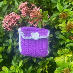 A close-up of the AirPod pouch. You can see the little white heart I crochet onto the flap for a cute touch.