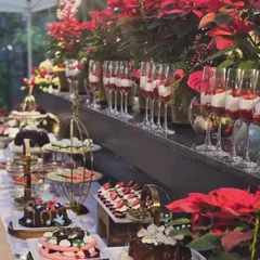 For a corporate Christmas event, I designed this lavish dessert table. The spread was decorated with festive poinsettia flowers and elegant tiered platters, creating a visually appealing and delicious experience for guests.