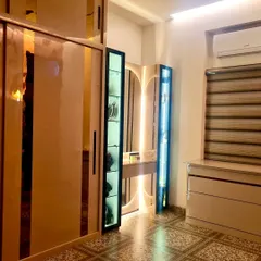A wider view of the closet room, showcasing the spacious sliding wardrobe with reflective panels, the custom vanity, and the stylish patterned floor tiles.