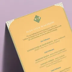 A 'Plan Your Wardrobe' card designed for a destination wedding in Udaipur. This simple, elegant card lists the dress code for each function, from 'Ethnic Exuberance' for the Mehendi to 'Cocktail' for the Sangeet Soiree.