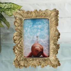 An elegant photo frame with a feathered or leaf-like texture in a soft, brushed gold finish. Its organic shape adds a touch of nature-inspired beauty to your favorite pictures.