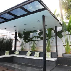 A close-up of the gazebo's interior, showing the built-in seating and the frosted glass roof panels that provide shade while keeping the space bright. The design is both practical and stylish.
