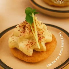 We love to reinvent classics. Here, we've transformed a traditional papdi into a modern canapé, featuring a crisp base with a delicately piped, spicy chickpea mousse. This single bite delivers a complex texture and flavour profile, perfect for starting a gourmet journey.