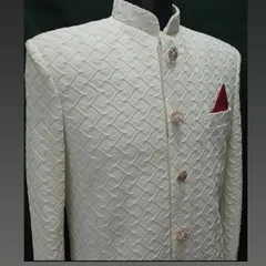 A closer look at the textured fabric and ornate buttons of the off-white sherwani. Every detail is chosen to enhance the final garment.