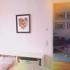 My custom Tiranga heart painting, framed and hung in a client's home. It adds a pop of color and personal meaning to this bright, modern room. You can see how it fits beautifully into the corner of this space.