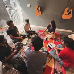A traditional, floor-seated Hindustani vocal session in progress. We honor the classical roots of Indian music in our teaching methods.
