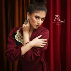 For this high-fashion portrait, we created a rich, moody atmosphere using a simple red curtain and focused lighting. I guided the model to convey a strong, confident expression, perfect for an editorial look or a designer's collection.