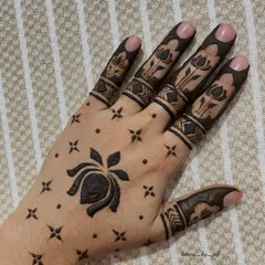 A striking minimalist design with a large lotus flower on the back of the hand, surrounded by small stars and dots. The fingers have matching lotus bands.
