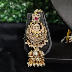 The matching passa from this set, designed to be worn on the side of the head for a complete, regal bridal look.