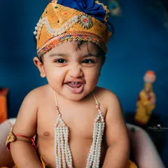 Look at that cheeky grin! Dressing up little ones for festive shoots like Janmashtami is one of my favorite things to do. I love capturing these playful, mischievous expressions that truly show their personality.