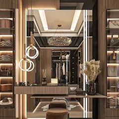 This is a walk-in wardrobe we designed for a client, featuring a dedicated vanity table with a large mirror and custom lighting. The glass-fronted cabinets with internal lighting make it easy to see and organize clothes and accessories.