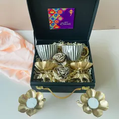We love creating gifts that are both beautiful and useful. This elegant black suitcase hamper features a set of modern ceramic cups and golden elephant t-light holders, perfect for a sophisticated festive gift.