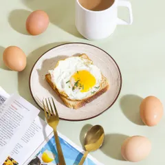 A classic breakfast scene styled for an egg brand, complete with a newspaper and coffee. This top down flatlay shot creates a relatable morning moment, showcasing the product as part of a perfect start to the day.
