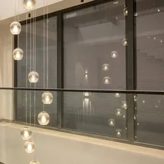 The reflection of the pendant lights in the large glass windows creates a beautiful, layered effect at night, blurring the boundary between the interior and the sky.
