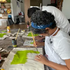 A participant painting her tote bag at our open house workshop. You can paint anything you like, making it a truly personal and wearable piece of art.