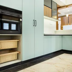 Smart storage is key to a calm kitchen. Here, I designed a tall unit to house the built-in oven, with open niches below for pull-out wicker baskets. It's a perfect solution for storing vegetables or linens, adding a touch of rustic charm.