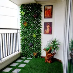 Even a small balcony can become a charming green corner. Here, I used artificial turf with square pavers to create a patterned floor, complemented by a leafy trellis wall for added privacy and greenery.