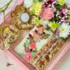 My artisanal gift hampers are perfect for any festival or special occasion. This 'Festive Bloom' Diwali hamper combines hand-painted white chocolate, a savory crunch mix, and fresh flowers for a truly elegant gift.