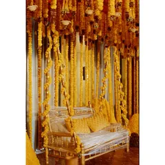 A traditional Indian swing (jhoola) decorated lavishly with strings of bright yellow marigolds, creating a perfect photo spot for a Mehendi or Haldi ceremony.