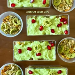 An overhead view of my Chatpata Chaat Cups ready to be served. Each cup is a delightful mix of textures and flavors, topped with bright pomegranate jewels and a swirl of mint cilantro chutney.