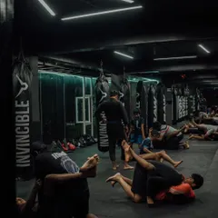 The floor is where the chess match of Jiu-Jitsu happens. Here you see a class practicing grappling techniques, learning how to control an opponent on the ground.