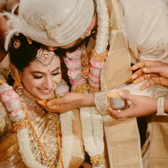 A beautiful moment from a South Indian wedding ceremony. The groom gently blesses the bride, their faces full of emotion and reverence for the ritual.