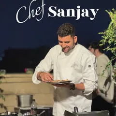 Chef Sanjay carefully plating appetizers at an outdoor event. Our chefs work in any environment to deliver exceptional food.