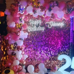 We love a bit of glam! This 21st birthday setup features a vibrant pink and rose gold balloon arch against a sparkling sequin wall, complete with a custom neon sign for that perfect party picture.