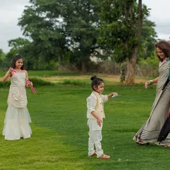 A mother and her children enjoying a playful moment with bubbles in a lush green field. Our outdoor family sessions are perfect for capturing these candid, activity-based photos where kids can have fun.