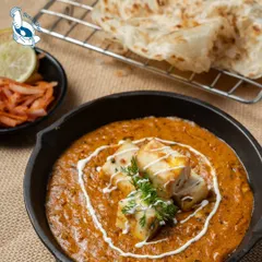A close up of our signature paneer dish, served in a cast iron pan to keep it warm. The creamy tomato based gravy is a crowd pleaser, perfect with any Indian bread.