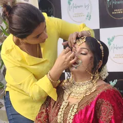 A behind-the-scenes shot of me working on a traditional Rajputana bride, focusing on the intricate eye makeup.